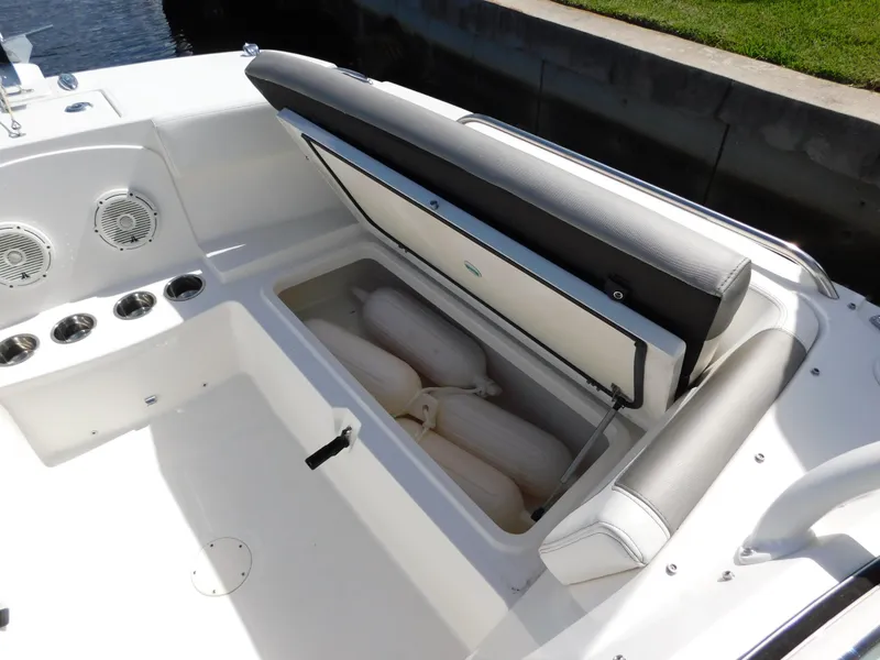 Slide: The Image of 2020 World Cat 230 DC boat interior with open storage compartment and fenders. - 30