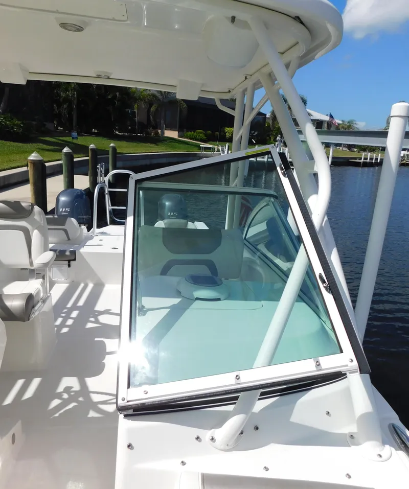 Slide: The Image of 2020 World Cat 230 DC boat docked by a serene waterfront. - 39