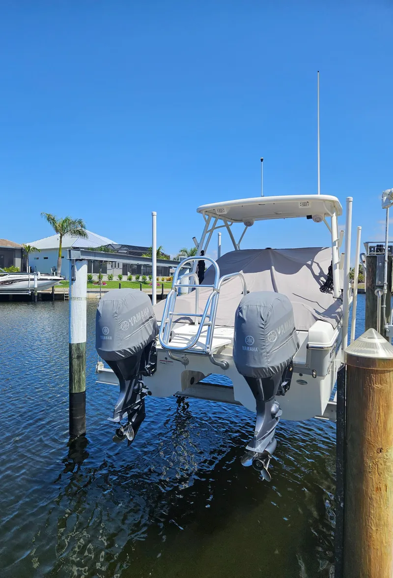 Slide: The Image of 2020 World Cat 230 DC boat docked with dual engines, under clear blue sky. - 5
