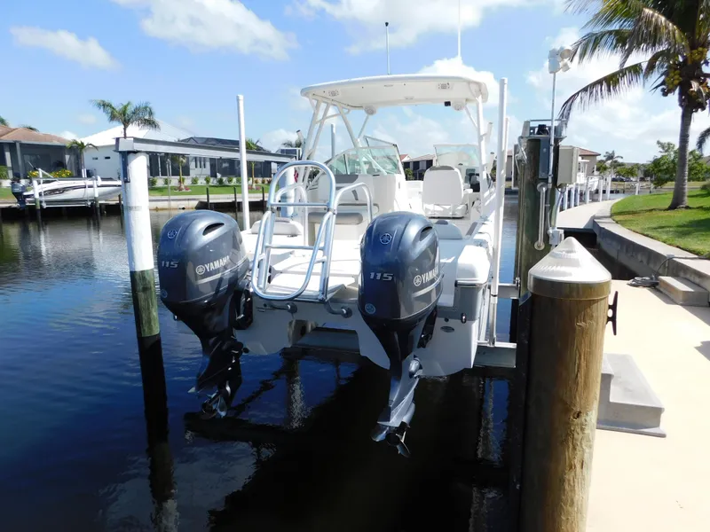 Slide: The Image of 2020 World Cat 230 DC boat with twin Yamaha engines docked by a canal. - 6