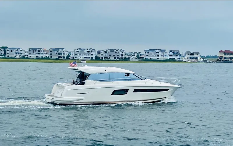 Slide: The Image of 2017 Prestige 500 S yacht cruising on a coastal waterway with houses in the background. - 0