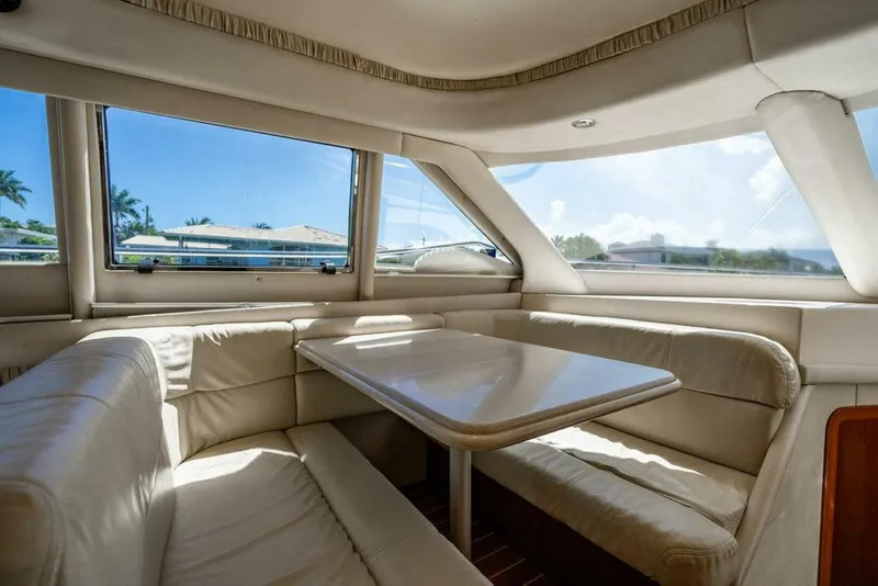 Slide: The Image of Interior of 1999 Sea Ray 56 Sedan Bridge yacht with plush seating and table. - 14