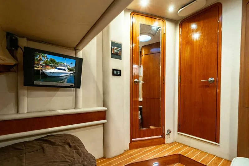 Slide: The Image of Interior of 1999 Sea Ray 56 Sedan Bridge with wood paneling and mounted TV. - 22
