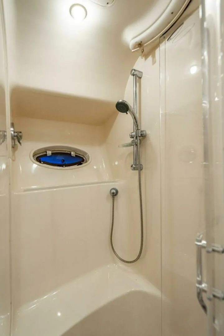Slide: The Image of Shower area in 1999 Sea Ray 56 Sedan Bridge yacht, featuring modern fixtures and porthole window. - 24