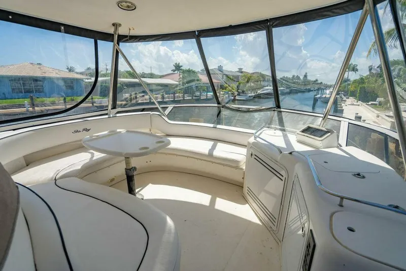 Slide: The Image of 1999 Sea Ray 56 Sedan Bridge yacht interior with panoramic windows and seating area. - 28