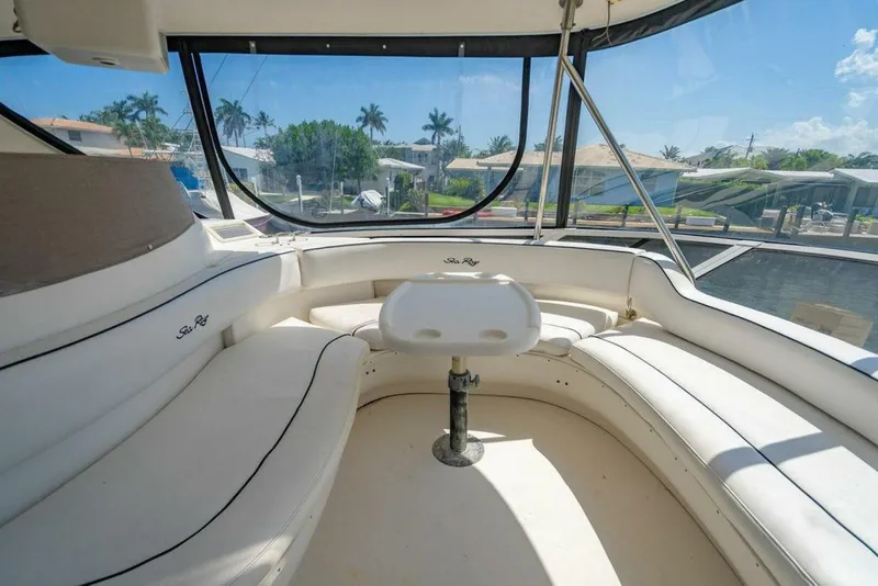 Slide: The Image of 1999 Sea Ray 56 Sedan Bridge yacht interior with white seating and panoramic windows. - 29