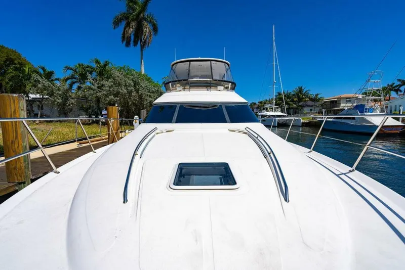 Slide: The Image of 1999 Sea Ray 56 Sedan Bridge yacht docked, showcasing sleek design and spacious deck. - 35