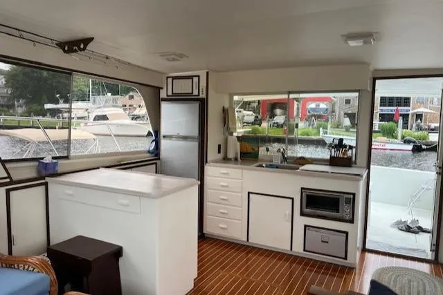 Slide: The Image of Interior of a 1980 Huckins Sports Cruiser with modern kitchen and waterfront view. - 14