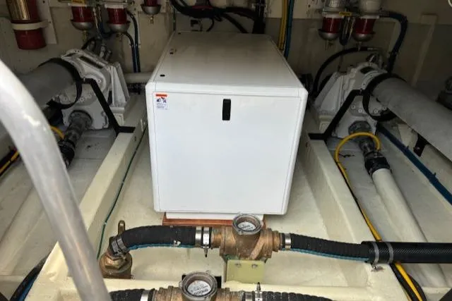 Slide: The Image of Engine room of 1980 Huckins Sports Cruiser with visible machinery and piping. - 25