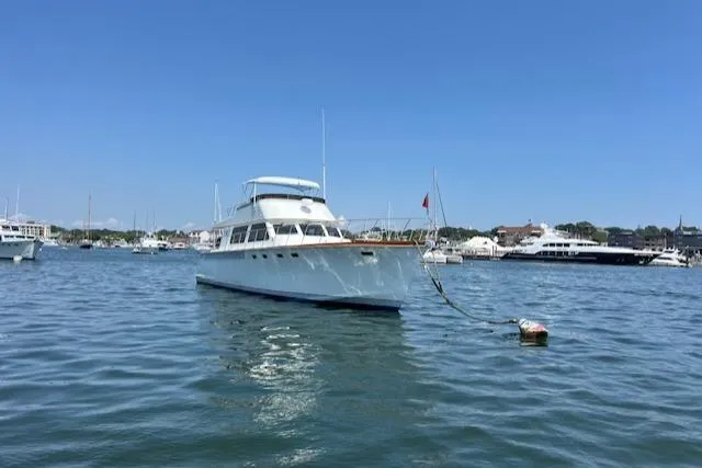 Slide: The Image of 1980 Huckins Sports Cruiser anchored in a sunny harbor. - 6