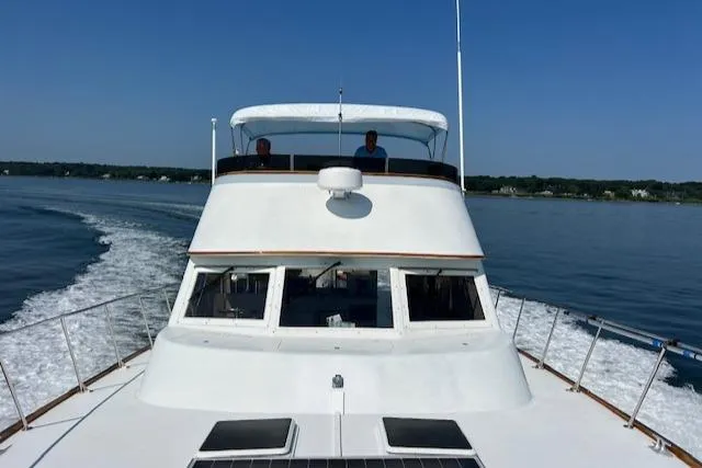 Slide: The Image of 1980 Huckins Sports Cruiser on calm water, clear sky, rear view. - 7