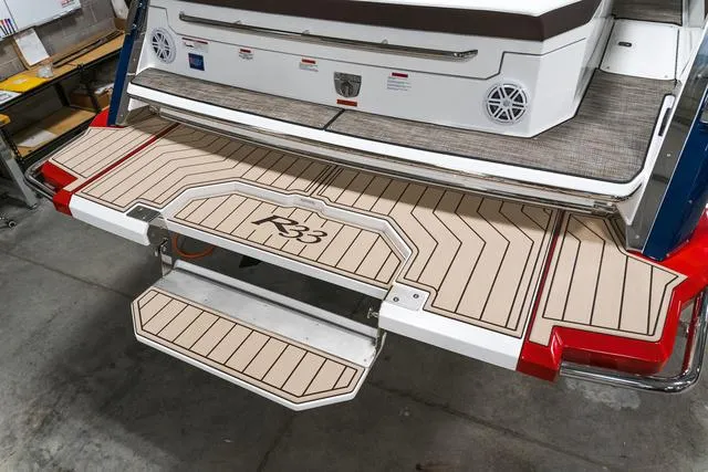 Slide: The Image of 2025 Cobalt R33 boat swim platform with teak-style decking and retractable ladder. - 2