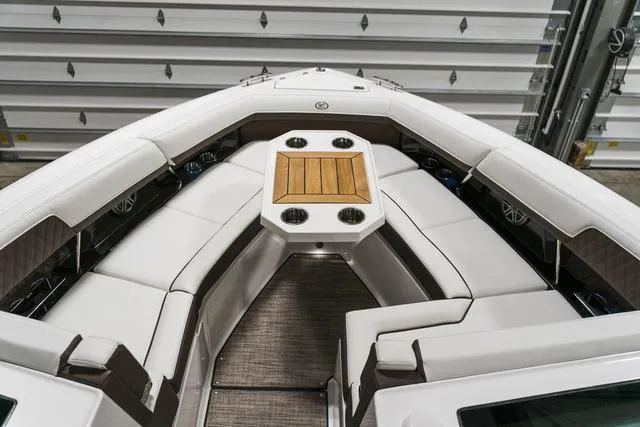 Slide: The Image of 2025 Cobalt R33 boat interior with white seating and wooden table. - 37