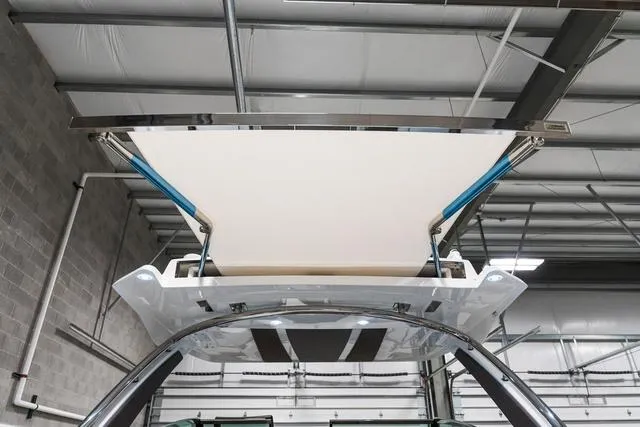 Slide: The Image of 2025 Cobalt R33 boat with retractable canopy in a warehouse setting. - 9