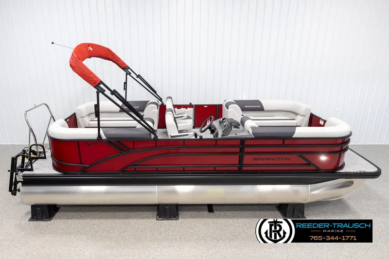 The Image of 2025 Bennington 22 SSRSE pontoon boat with red exterior and white seating, displayed indoors. - 1