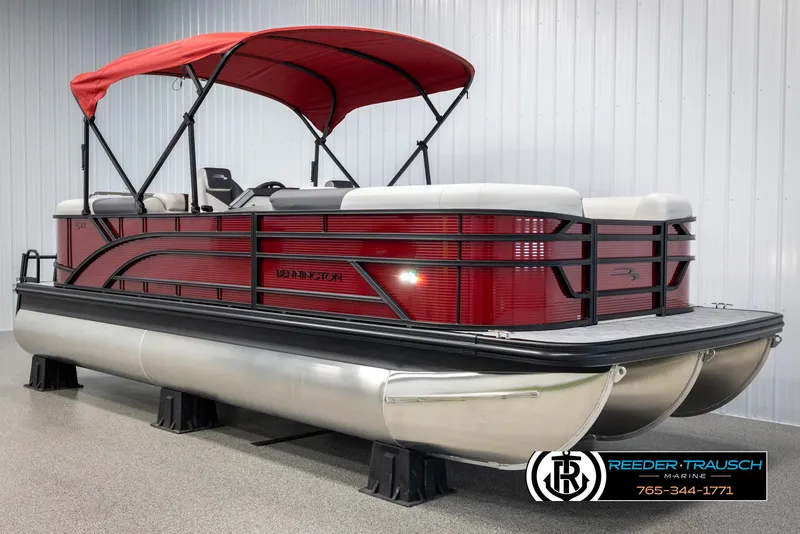 Slide: The Image of 2025 Bennington 22 SSRSE pontoon boat with red canopy and sleek design in showroom. - 3