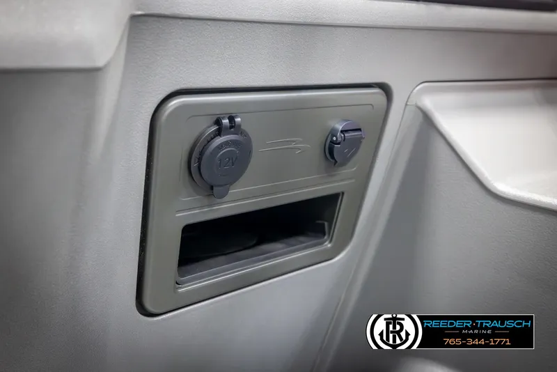 Slide: The Image of 2025 Bennington 22 SSRSE boat dashboard with 12V power outlet and storage compartment. - 31