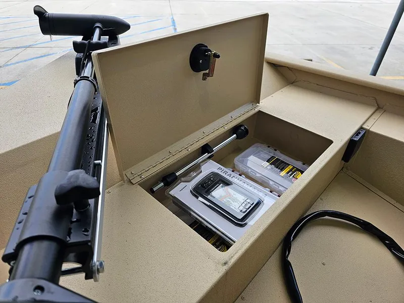 Slide: The Image of 2025 G3 Sportsman 1610 SS boat storage compartment with fishing gear and accessories. - 14