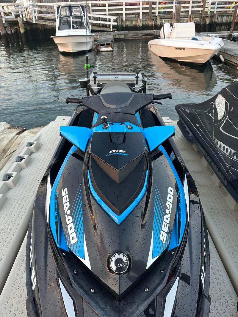 Slide: The Image of 2019 Sea-Doo GTR 230 jet ski docked at marina with boats in background. - 4