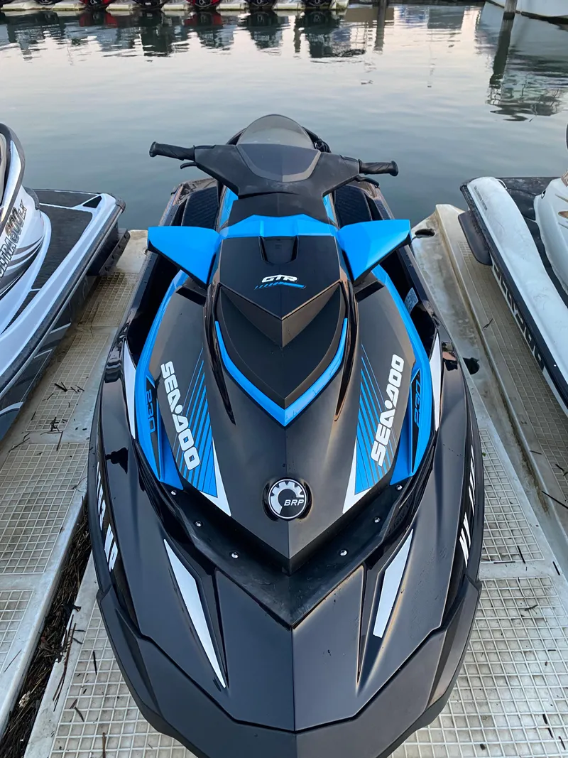 Slide: The Image of 2019 Sea-Doo GTR 230 jet ski docked, featuring sleek black and blue design. - 5