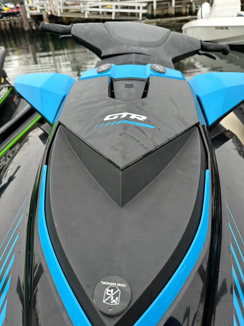 Slide: The Image of 2019 Sea-Doo GTR 230 jet ski, blue and black, docked by the water. - 7