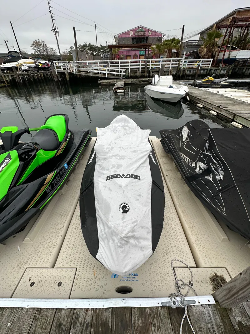 Slide: The Image of 2019 Sea-Doo GTR 230 jet ski covered on dock, beside water and other jet skis. - 9