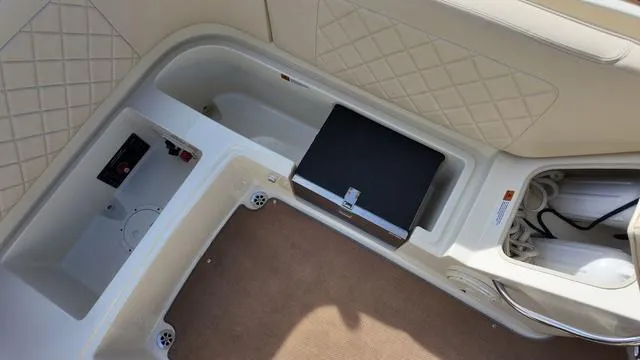 Slide: The Image of 2017 Chris-Craft Launch 27 interior storage compartments with quilted upholstery and carpeted flooring. - 13