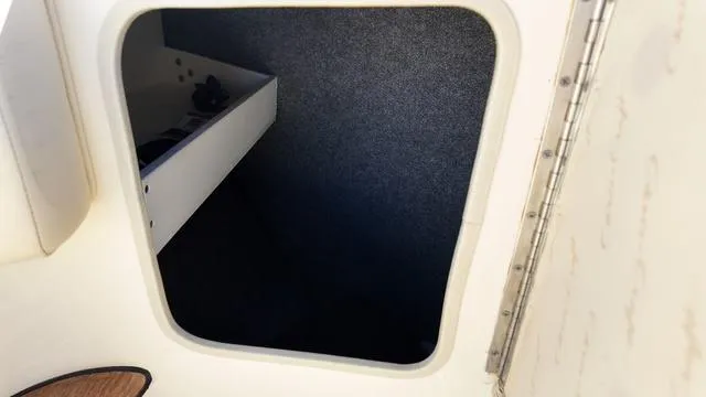 Slide: The Image of 2017 Chris-Craft Launch 27 storage compartment with open hatch and interior shelving. - 29
