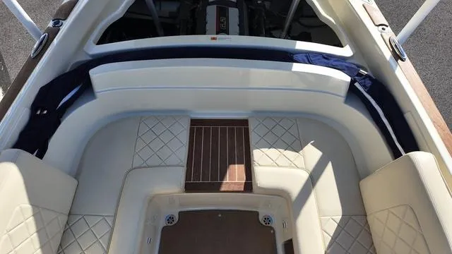 Slide: The Image of 2017 Chris-Craft Launch 27 boat interior with cushioned seating and engine compartment. - 32