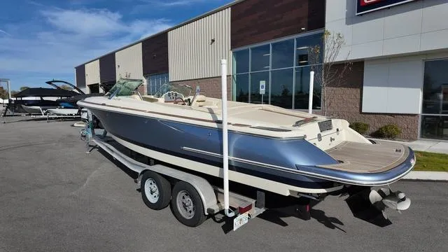 Slide: The Image of 2017 Chris-Craft Launch 27 boat on trailer, parked outside a building. - 4