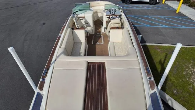 Slide: The Image of 2017 Chris-Craft Launch 27 boat interior with beige seating and wooden accents. - 7