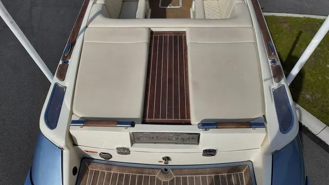 Slide: The Image of 2017 Chris-Craft Launch 27 boat, featuring elegant wood and cream upholstery, docked on pavement. - 8