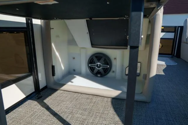 Slide: The Image of 2025 Barletta Corsa 23UC interior storage compartment with speaker, featuring modern design and carpeting. - 20