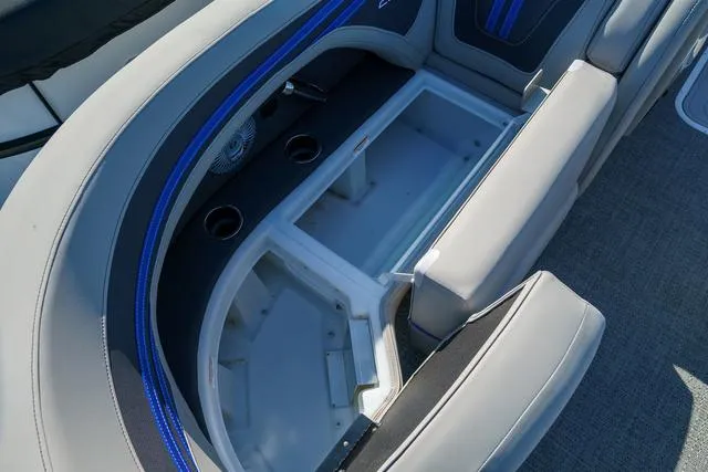 Slide: The Image of 2025 Barletta Corsa 23UC boat interior with open storage compartment and cup holders. - 9