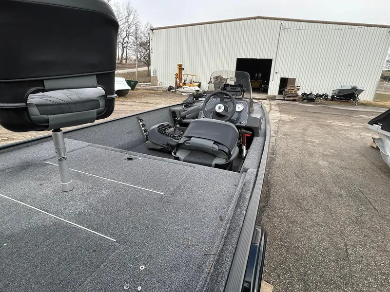 Slide: The Image of 2020 Tracker Bass Tracker Classic XL boat parked near a warehouse, showcasing its interior and seating. - 10