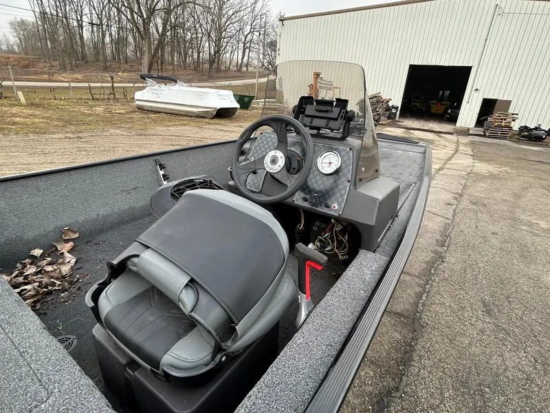 Slide: The Image of 2020 Tracker Bass Tracker Classic XL boat interior with steering wheel and gauges, parked outdoors. - 11
