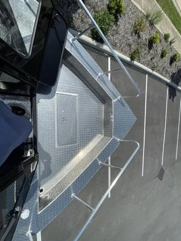 Slide: The Image of 2024 Thunder Jet Alexis OS 22' boat deck, parked on asphalt, with metal railings. - 39