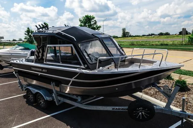 Slide: The Image of 2024 Thunder Jet Alexis OS 22' boat on trailer, parked outdoors under a cloudy sky. - 2