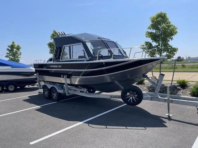 Slide: The Image of 2024 Thunder Jet Alexis OS 22' boat on trailer in parking lot, sunny day. - 3