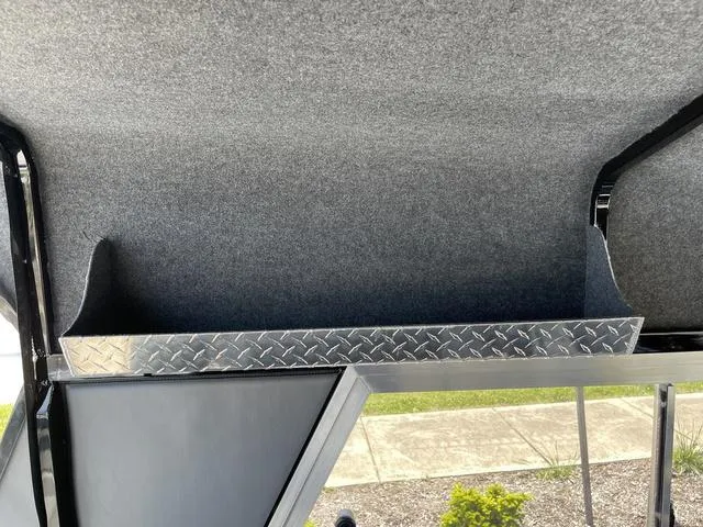 Slide: The Image of 2024 Thunder Jet Alexis OS 22' interior storage compartment with diamond plate trim. - 37