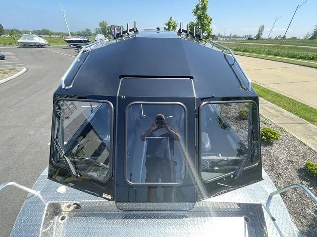 Slide: The Image of 2024 Thunder Jet Alexis OS 22' boat, top view, sleek black design, parked outdoors. - 41