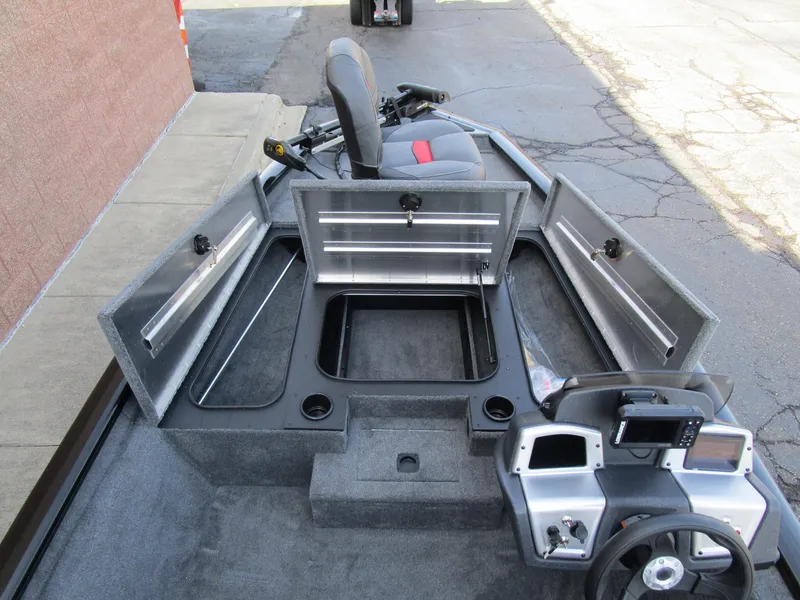 Slide: The Image of 2025 Tracker Pro Team 175 TXW boat interior with open storage compartments and steering console. - 7