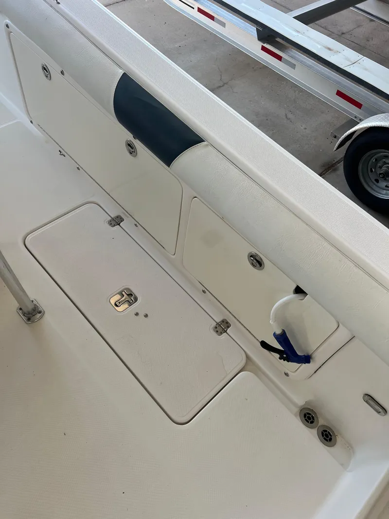 Slide: The Image of 2007 Century 2600 CC boat interior with storage compartments and trailer in background. - 11