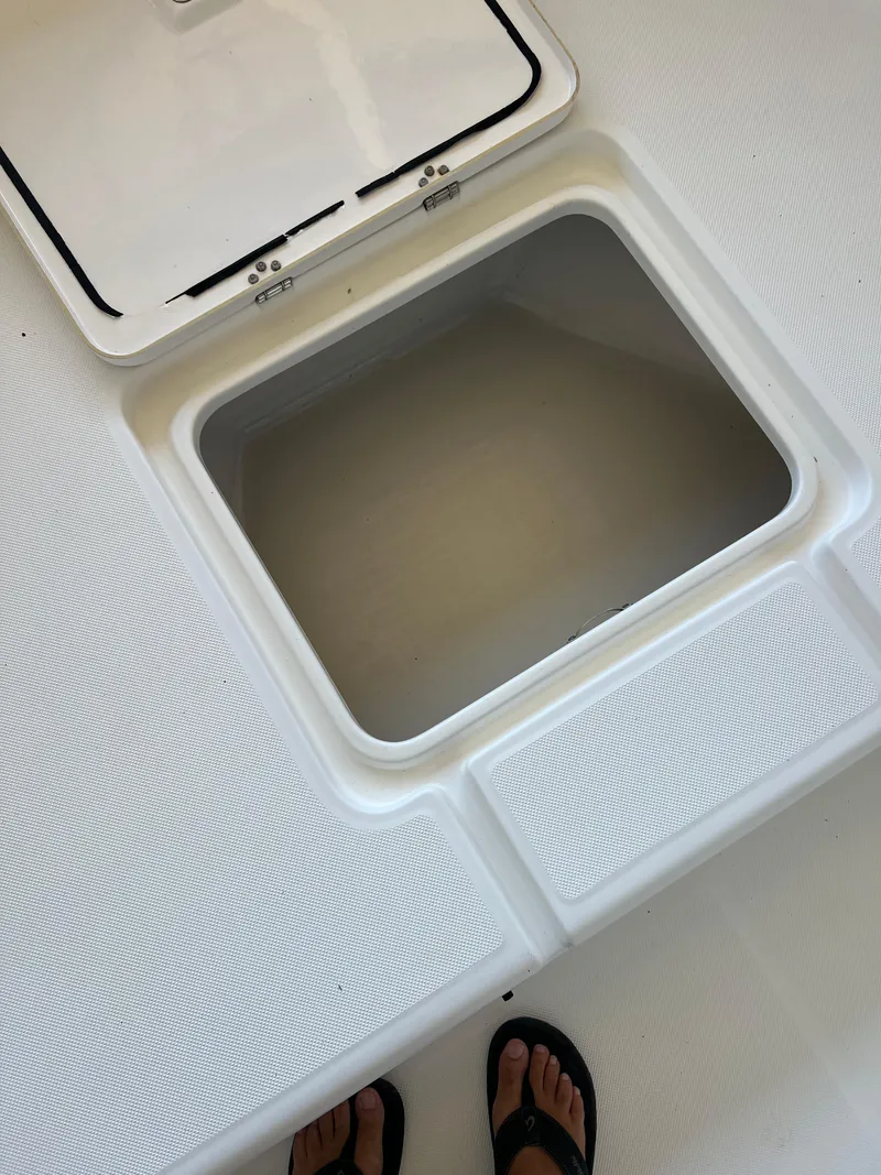 Slide: The Image of Open storage compartment on 2007 Century 2600 CC boat deck, with visible feet in sandals. - 18