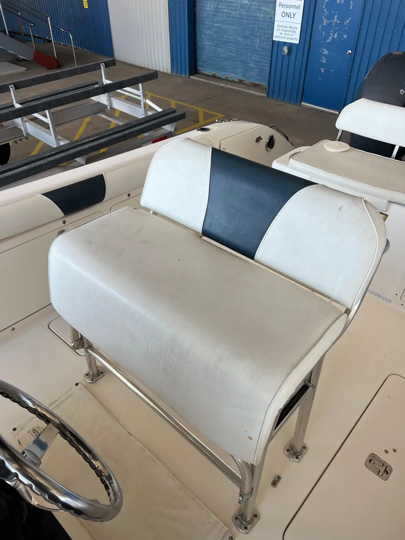 Slide: The Image of Century 2600 CC 2007 boat seat with white and blue upholstery in a marina setting. - 21