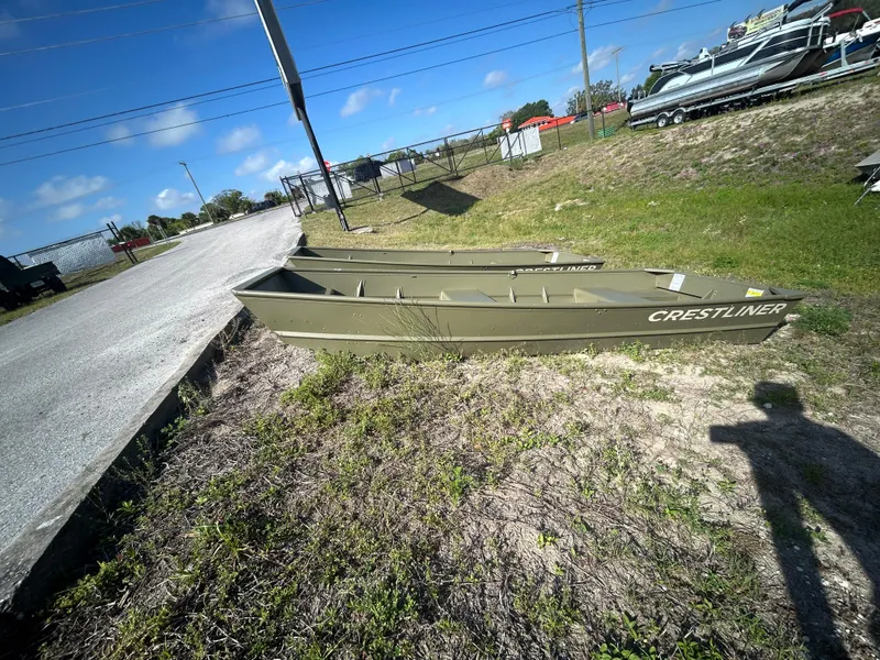 Slide: The Image of 2025 Crestliner CR1240 boat on grassy area near a road under a clear blue sky. - 1