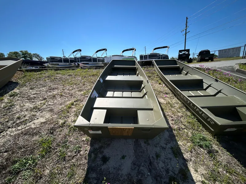 Slide: The Image of 2025 Crestliner CR1240 boat on display outdoors, surrounded by grass and other boats. - 10