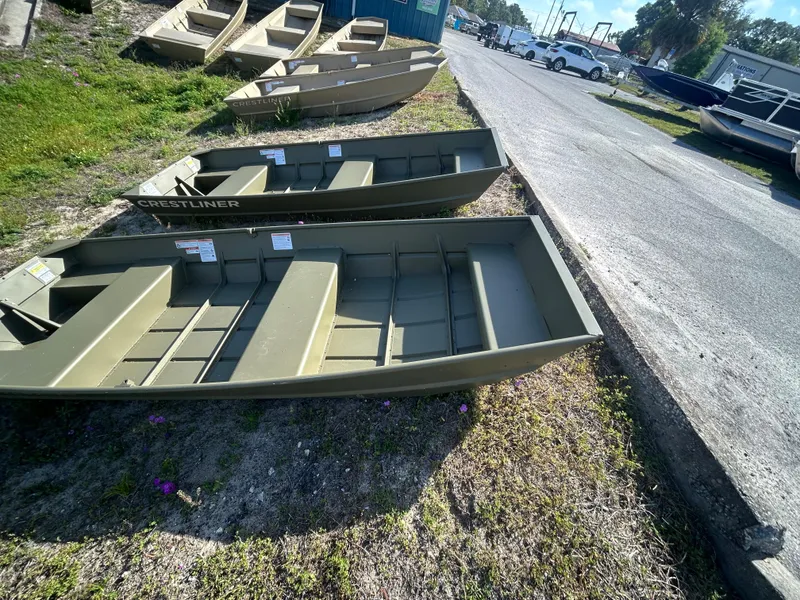 Slide: The Image of 2025 Crestliner CR1240 boats displayed outdoors on grass near a road. - 4