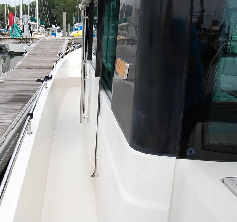 Slide: The Image of 2019 Axopar 37 SC boat docked at marina, side view with walkway and windows. - 10