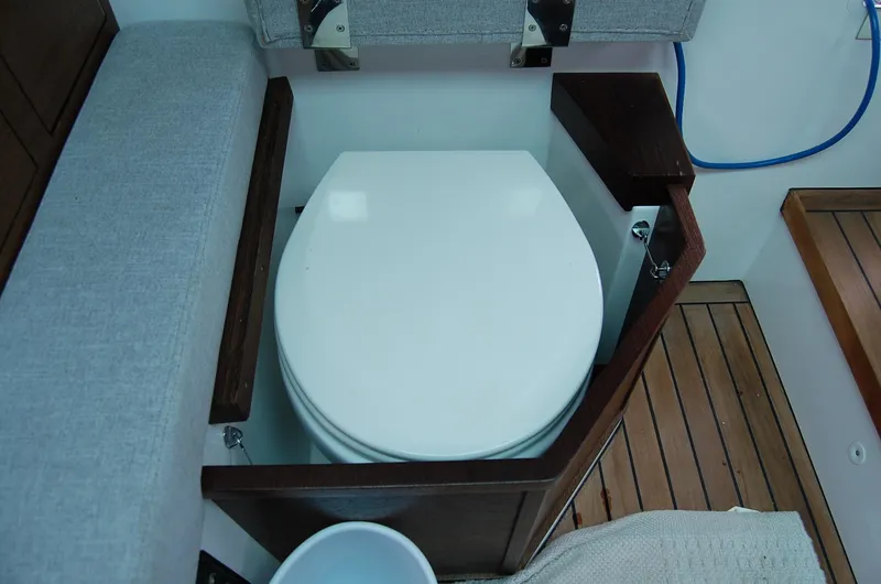 Slide: The Image of Toilet on 2019 Axopar 37 SC boat, featuring wooden accents and compact design. - 20